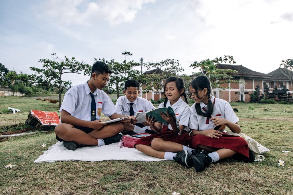 students reading outdoors